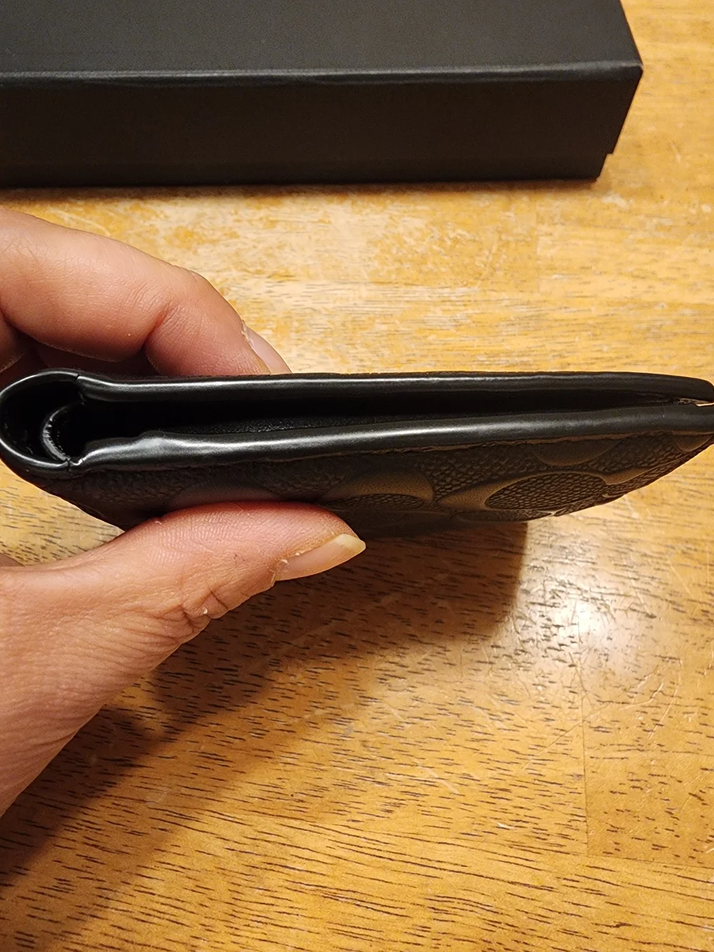 black Coach 3-in-1 wallet featuring the brand's iconic debossed signature pebble